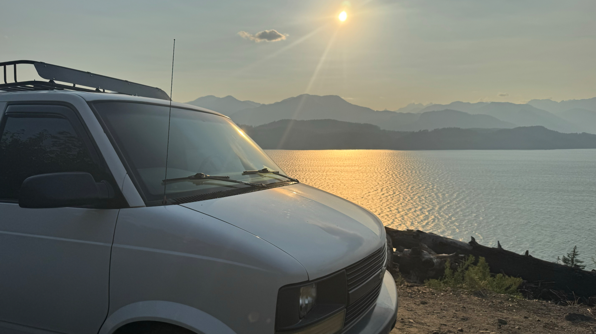 The Astro parked lakeside at golden hour with mountains in the distance
