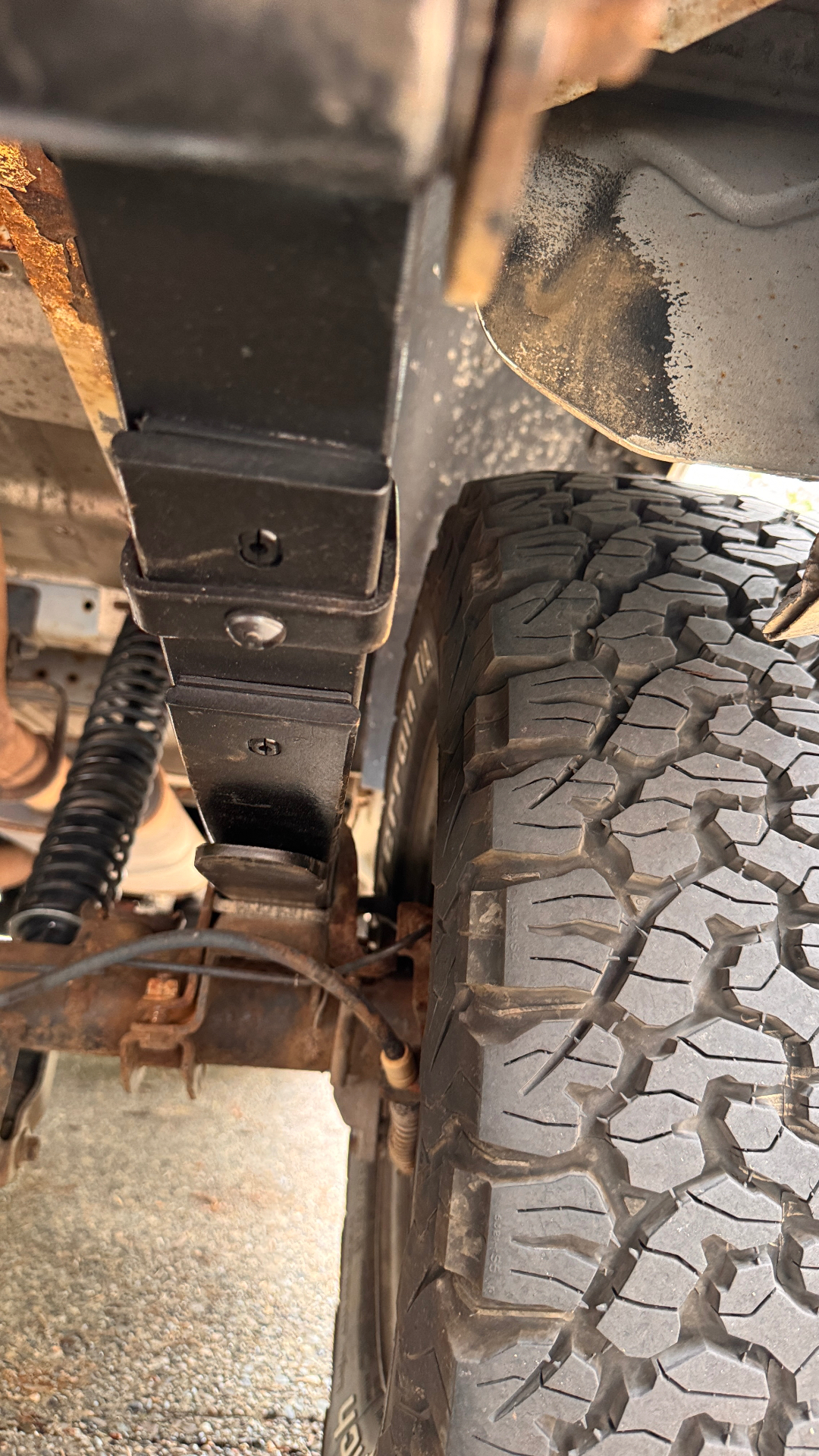 Close-up of the repositioned front leaf spring eye and hanger on the lifted 2WD Astro after the pinion angle correction at A&C Powersports.