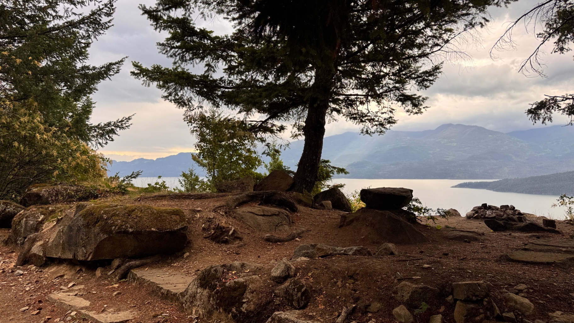 Evening light softening over the lake and boulders