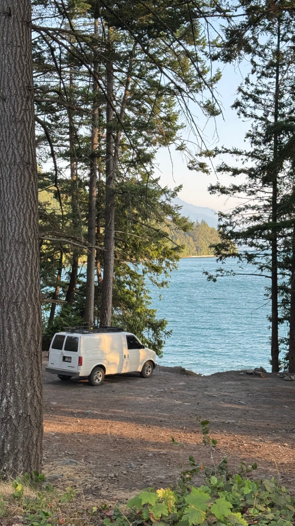 Van tucked into the trees above the lake