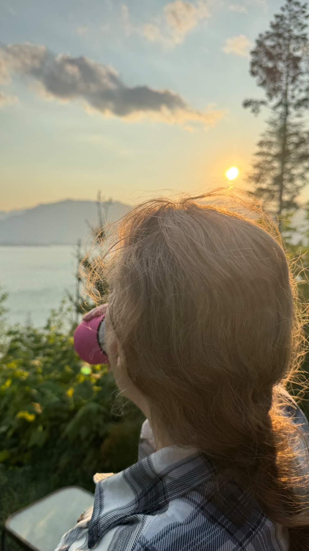 Tan watching the sun go down over the lake