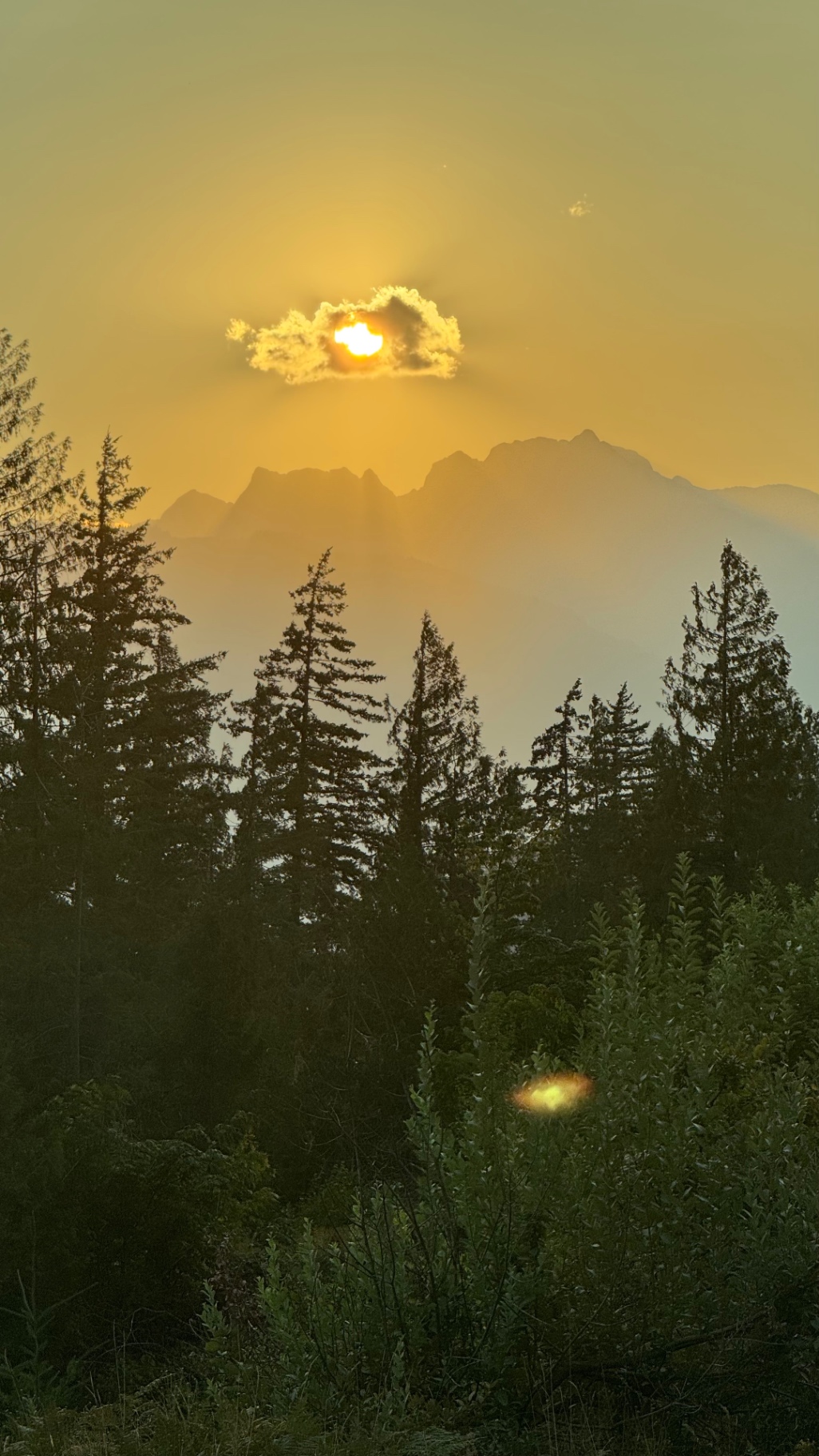 Sun breaking through clouds over the Coast Mountains