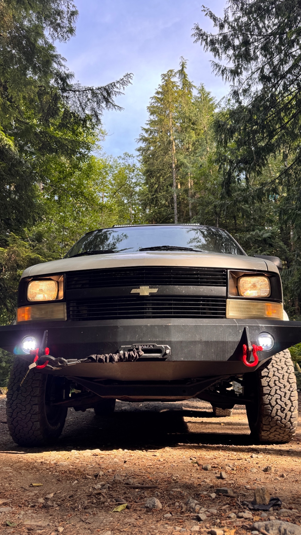 Low-angle front shot showing the two round fog lights burning bright in the JOR bumper with red recovery hooks