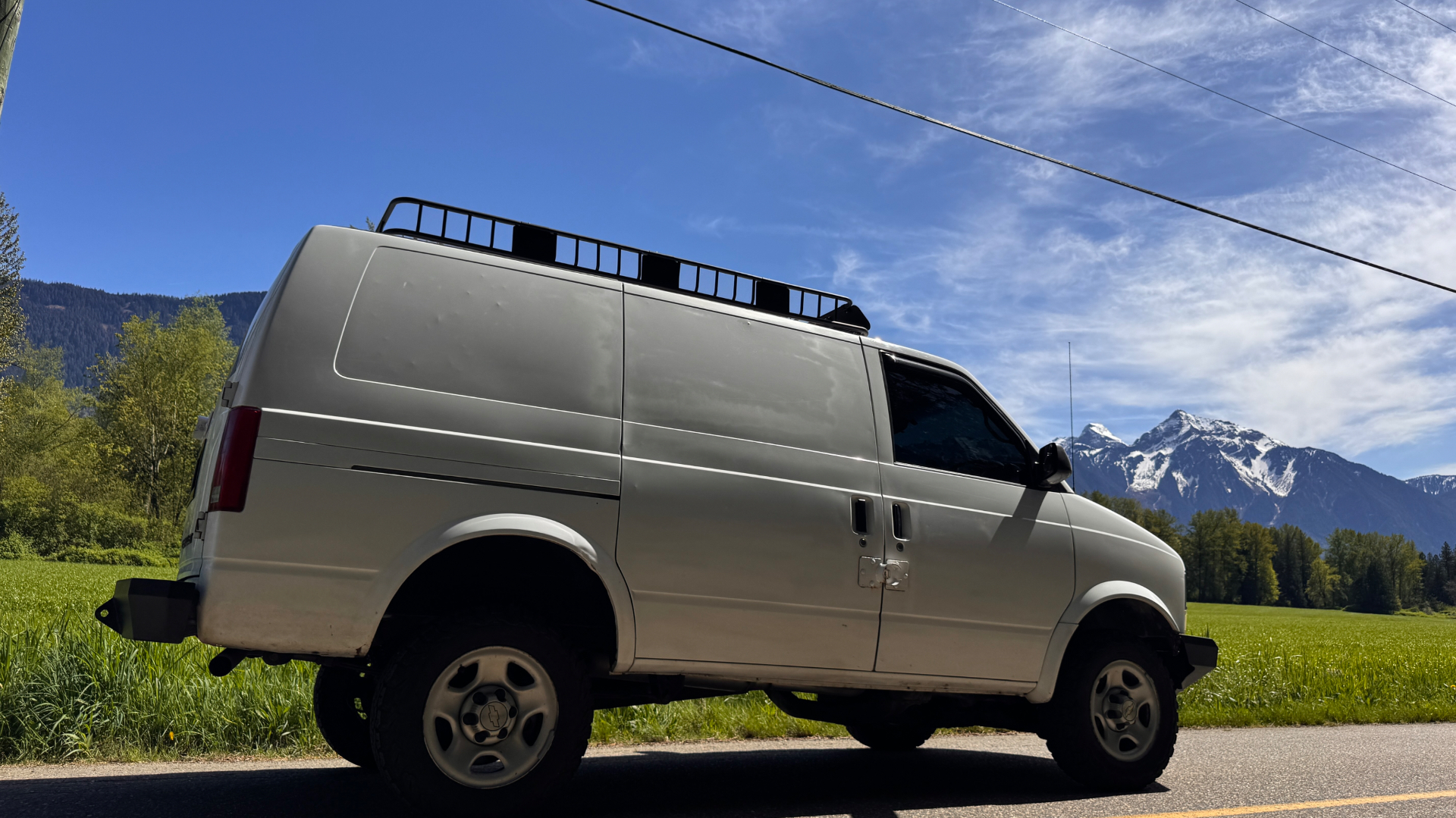 Astro parked roadside with snow-capped peaks across the field
